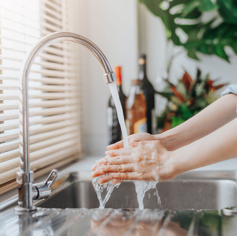 Woman washing hands in sink